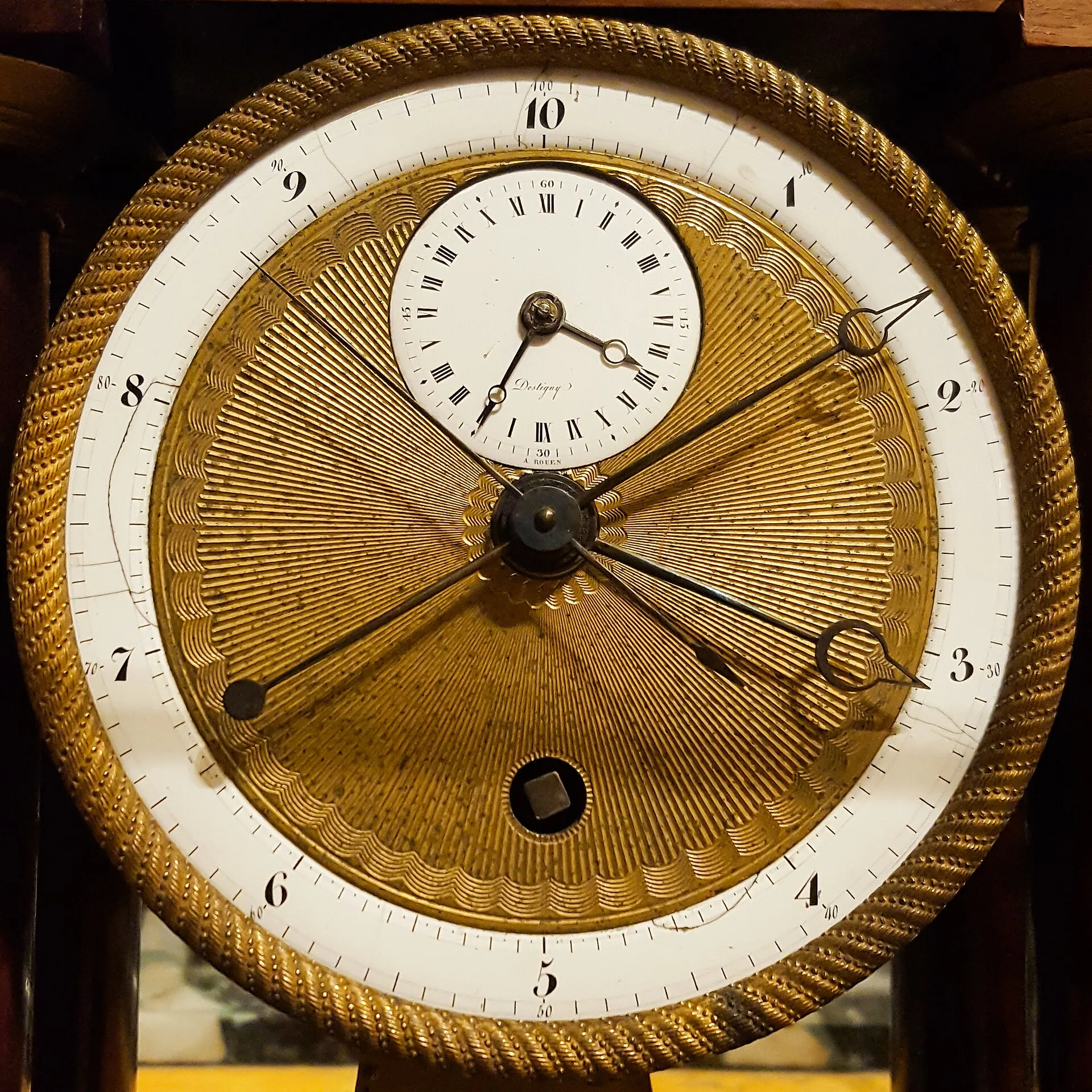 An enamel clock dial numbered 1 to 10, with a small conventional dial set inside it.