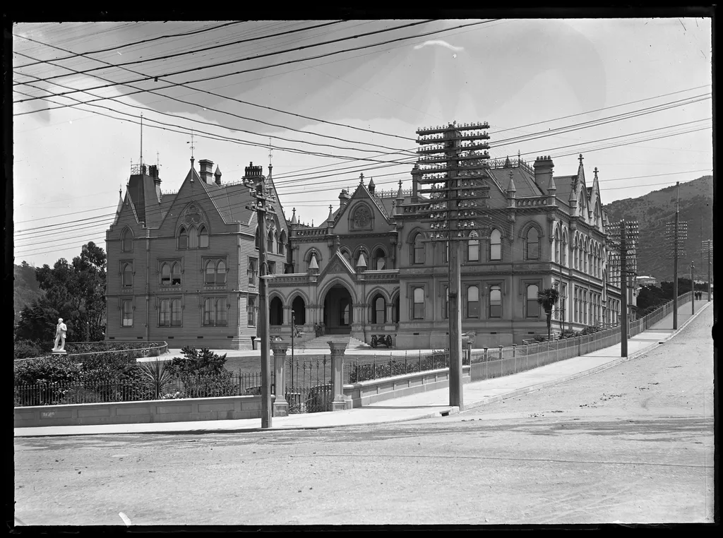 Black-and-white photograph of the Parliament Buildings in Wellington, with gardens in front.
